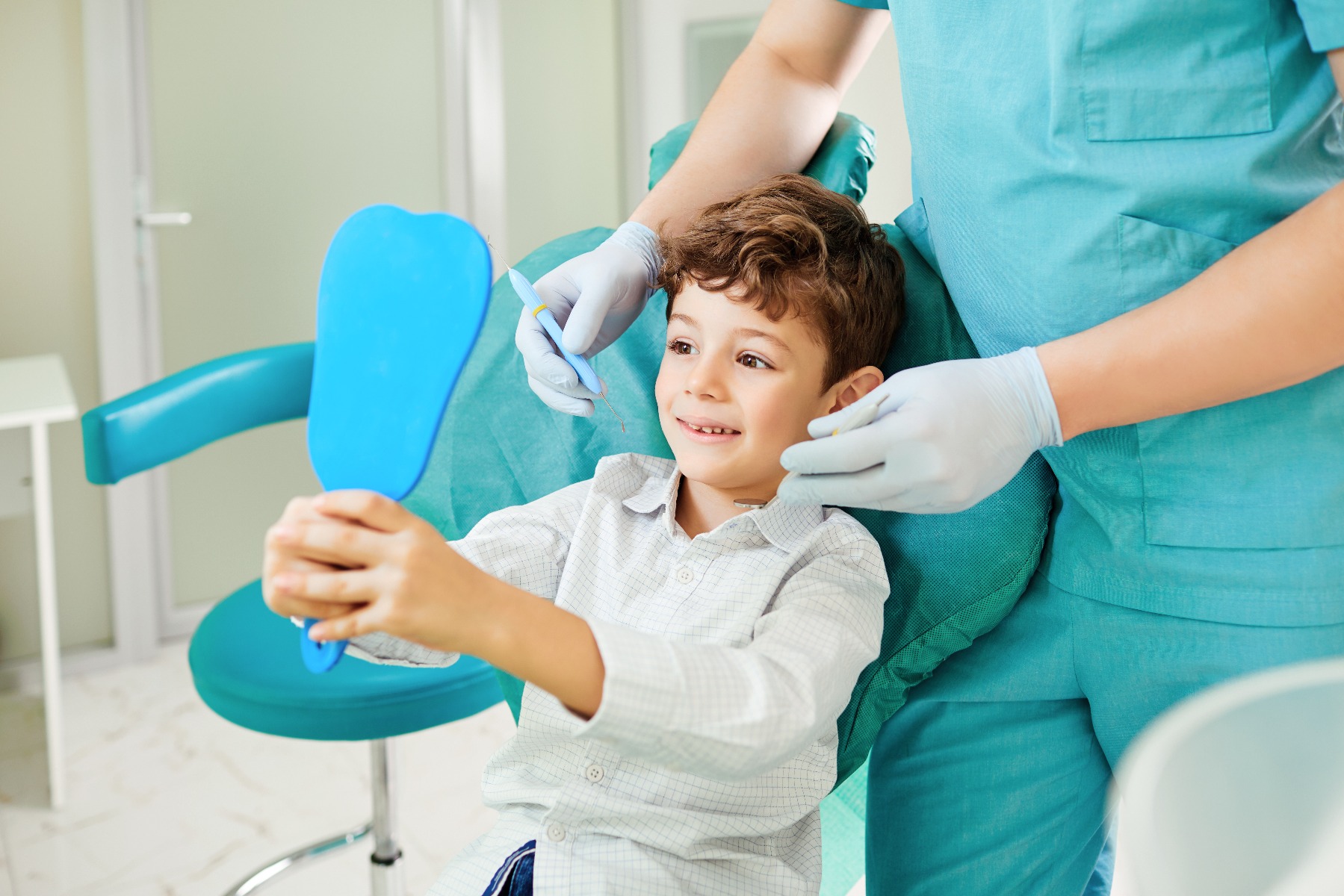 Kind lachend met spiegel bij tandarts 
